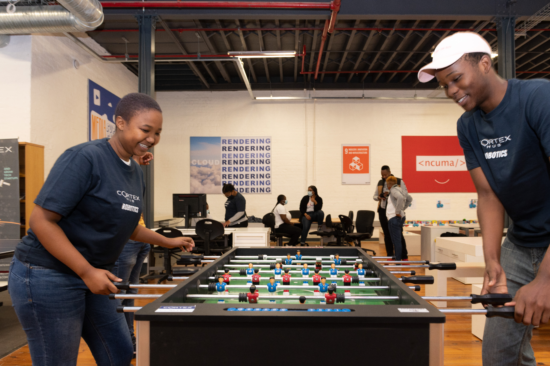 Two Cortex Hub participants playing foosball in the workspace