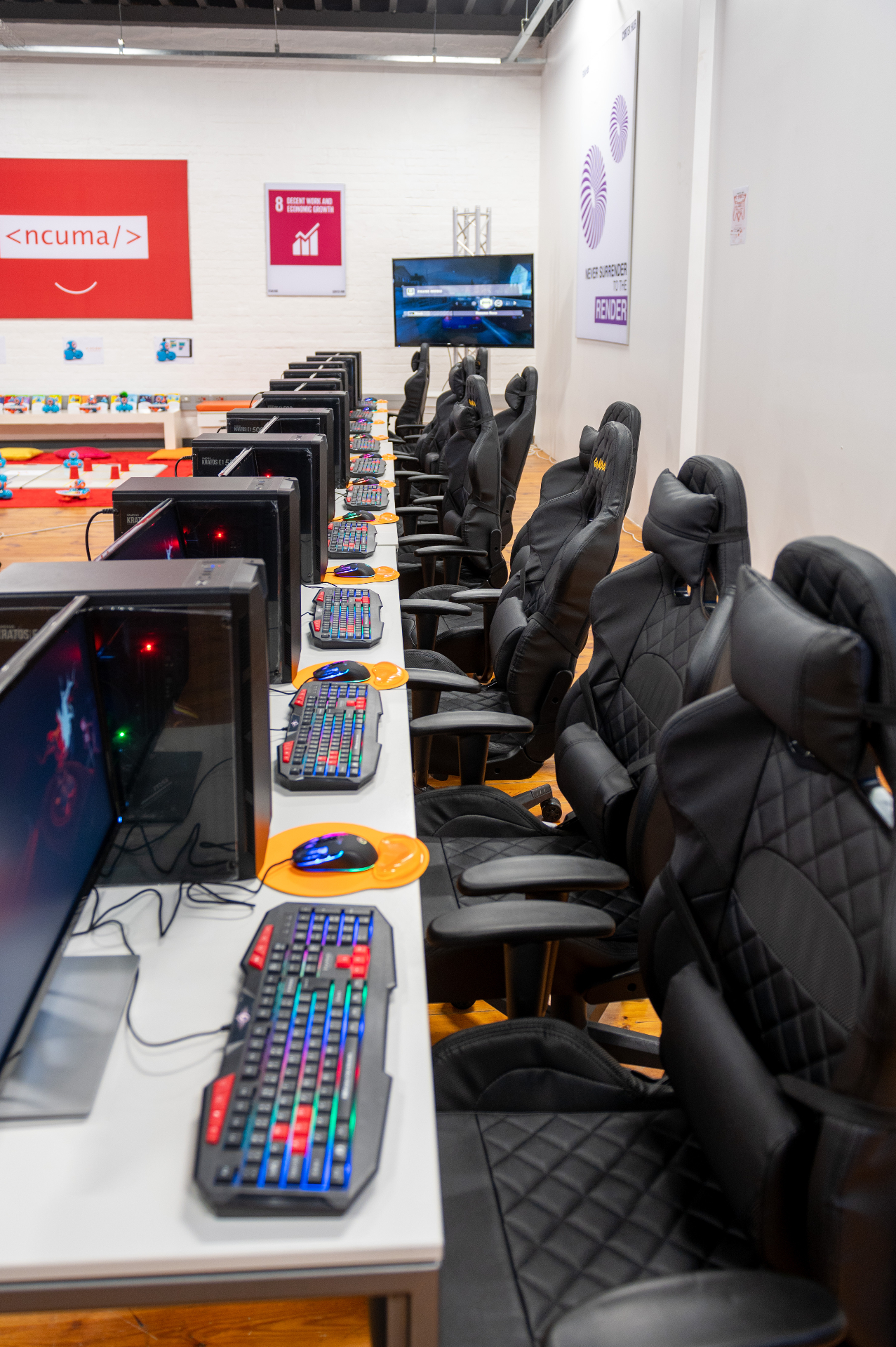 Row of gaming PCs with mechanical keyboards and racing chairs in the Hub's lab