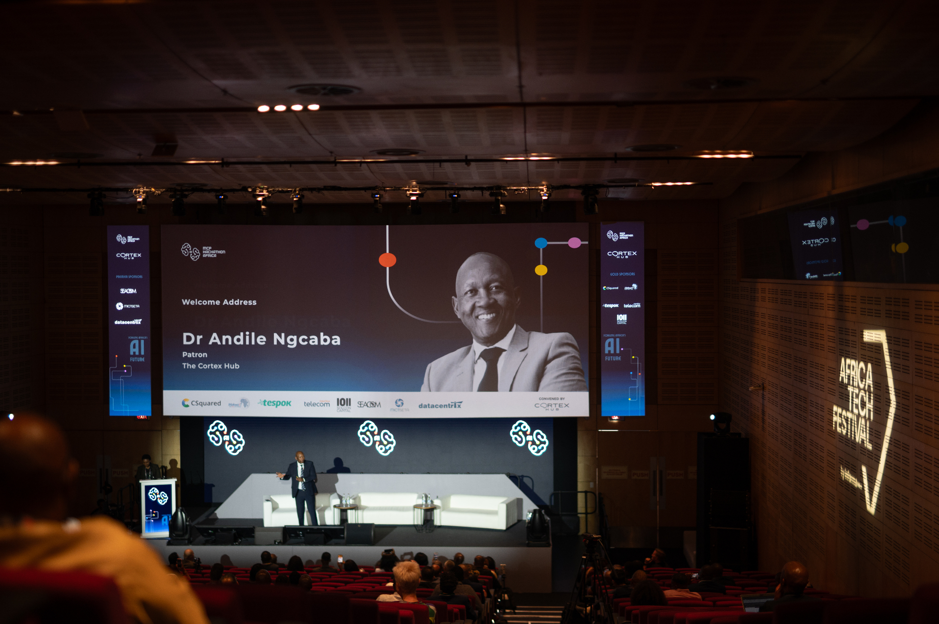 A Cortex Hub welcome address delivered on stage to a seated audience