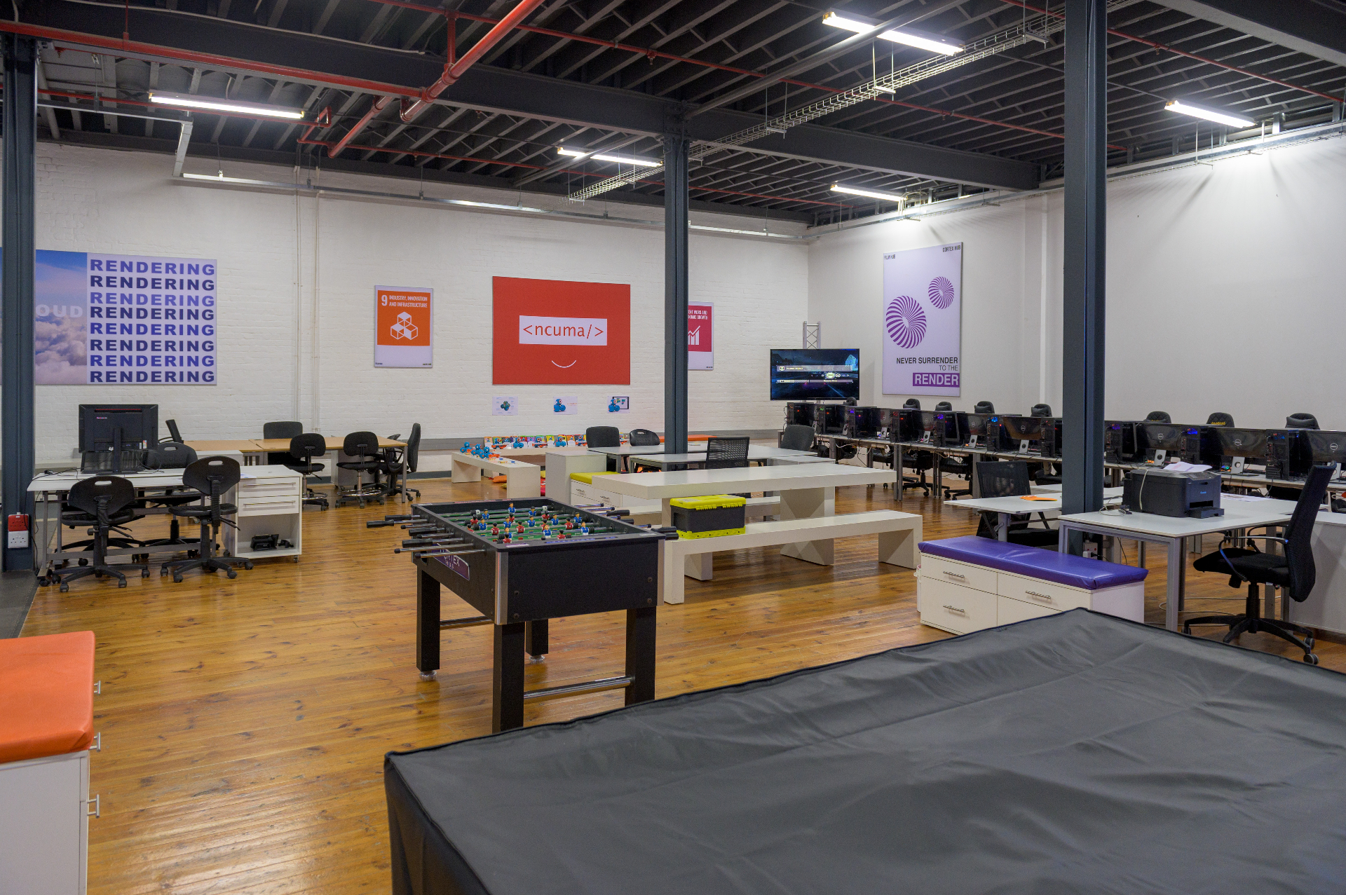 Open-plan workspace with desks, workstations and a foosball table at the Cortex Accelerator Hub