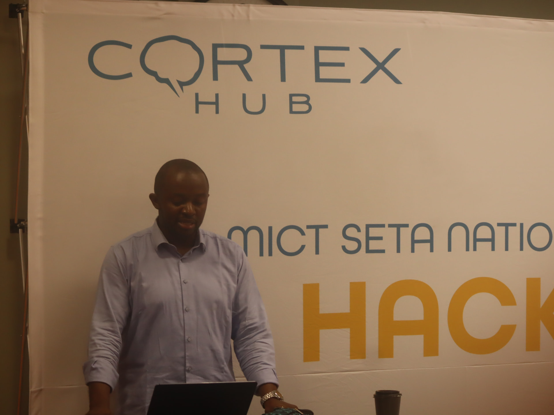 A speaker presenting in front of Cortex Hub and MICT SETA National Skills Challenge branding