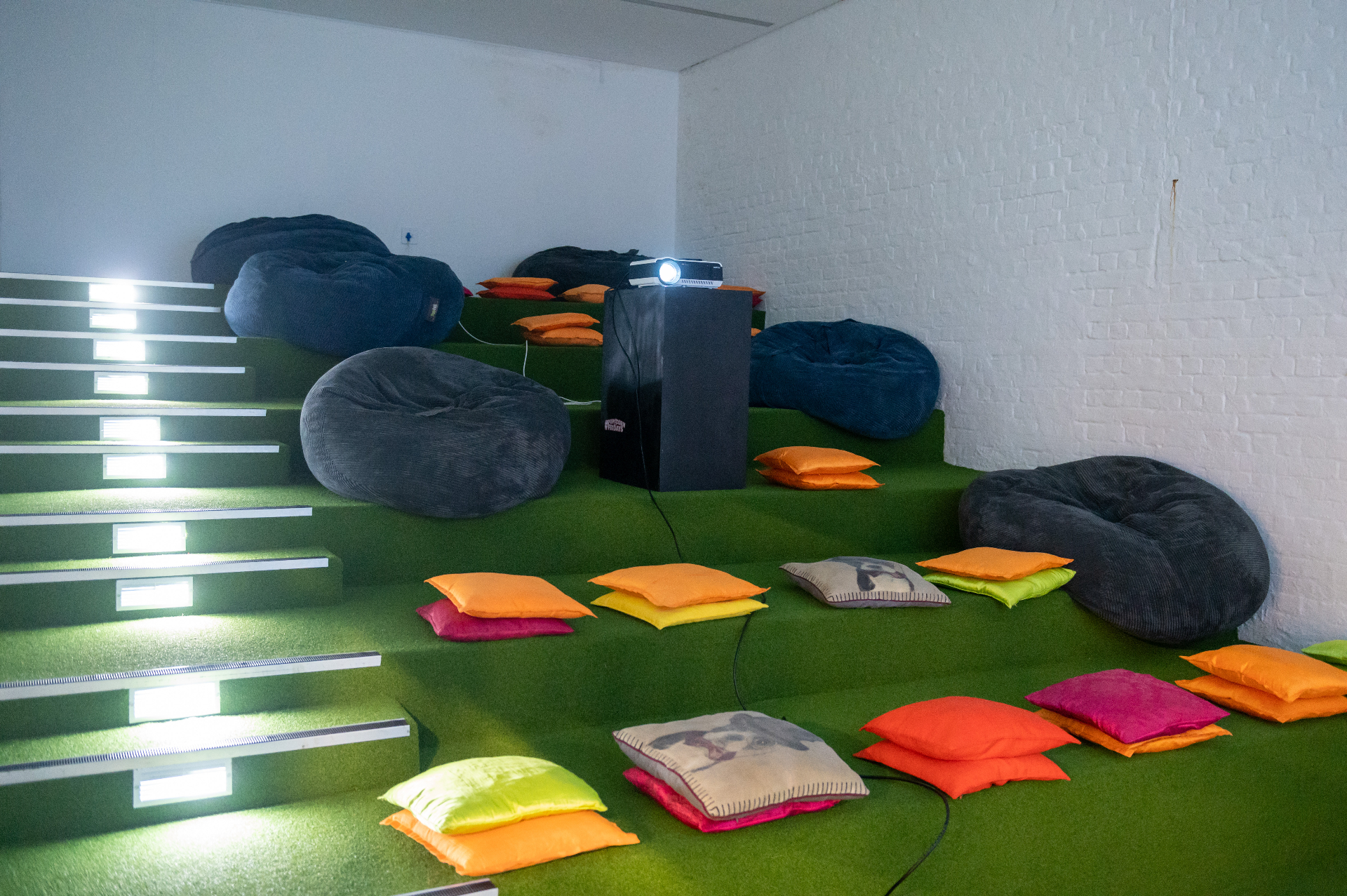 Tiered lounge with bean bags, cushions and a projector for screenings
